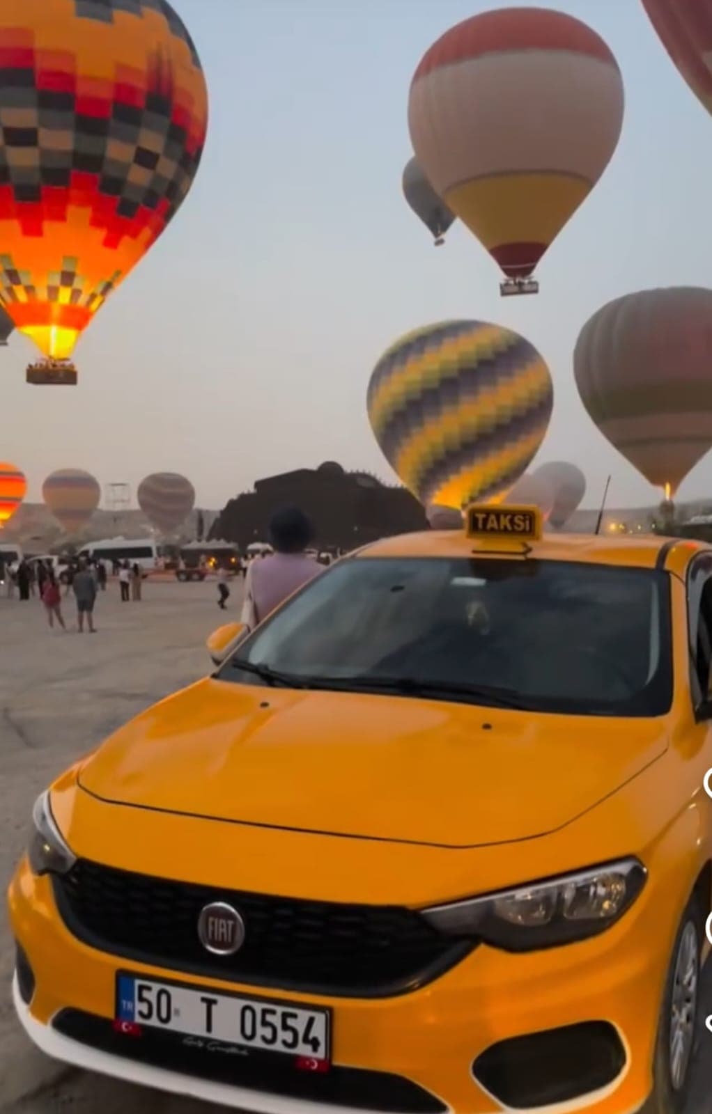 Yellow Göreme Taxi with hot air balloons in Cappadocia